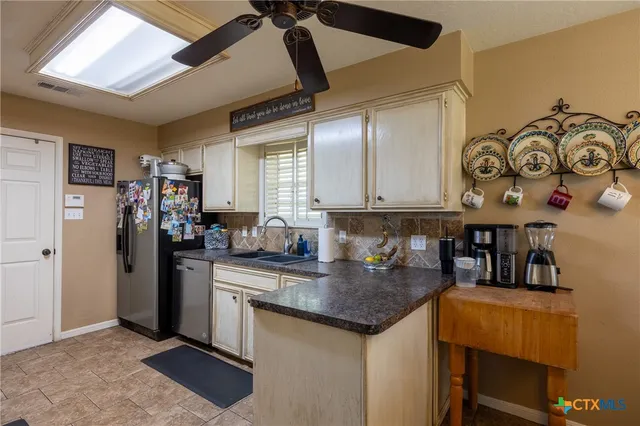 a kitchen with stainless steel appliances granite countertop a refrigerator and a sink