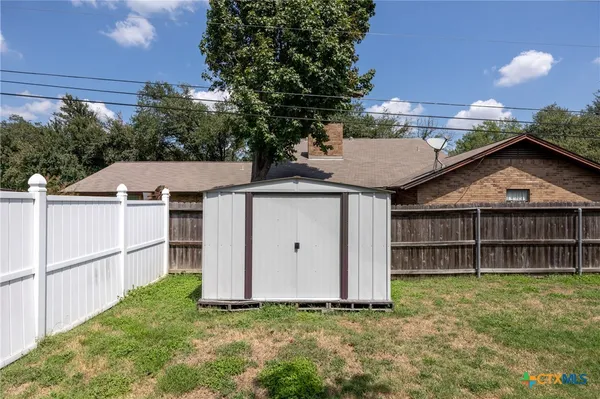 a view of a house with a yard and wooden fence