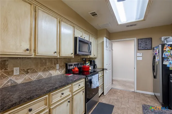 a kitchen with stainless steel appliances a sink stove and cabinets