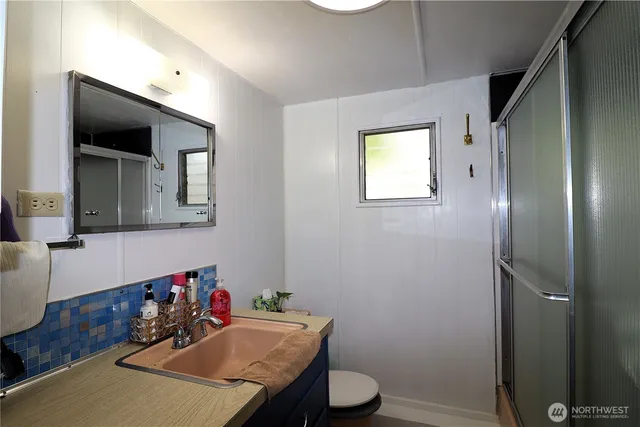 a bathroom with a granite countertop sink mirror vanity and toilet
