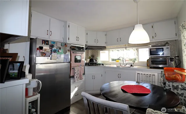 a kitchen with stainless steel appliances granite countertop a sink refrigerator stove top oven and cabinets