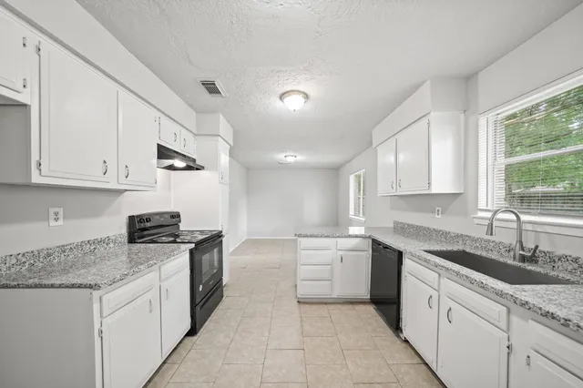 a kitchen with stainless steel appliances granite countertop a sink stove and cabinets