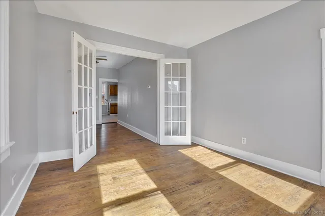 a view of a hallway with wooden floor and a living room