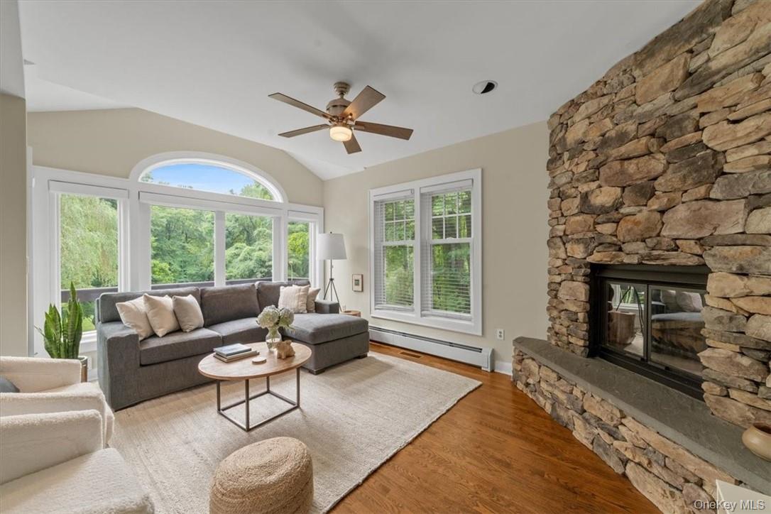 28 Inningwood Road Ossining, NY 10562 - Photo 10 of 37 Living room with a fireplace, hardwood / wood-style flooring, ceiling fan, vaulted ceiling, and baseboard heating