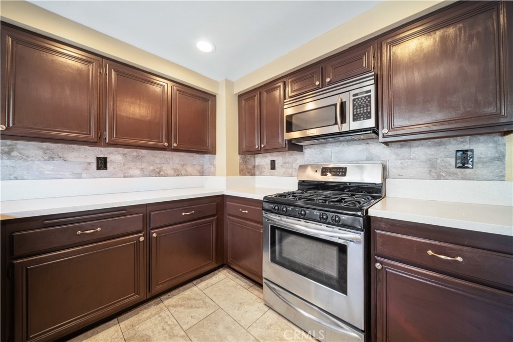 3 Saddlewood Lane Pomona, CA 91766 - Photo 14 of 40 a kitchen with granite countertop wooden cabinets stainless steel appliances and a sink