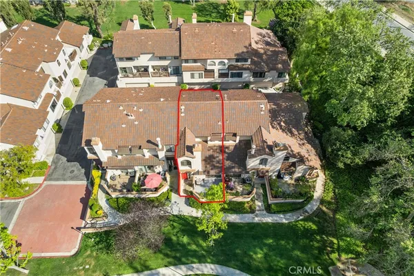 an aerial view of a house with a yard and a large tree
