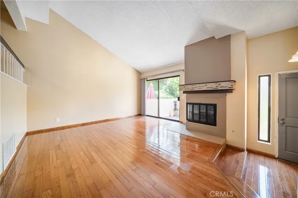a view of empty room with wooden floor and fireplace
