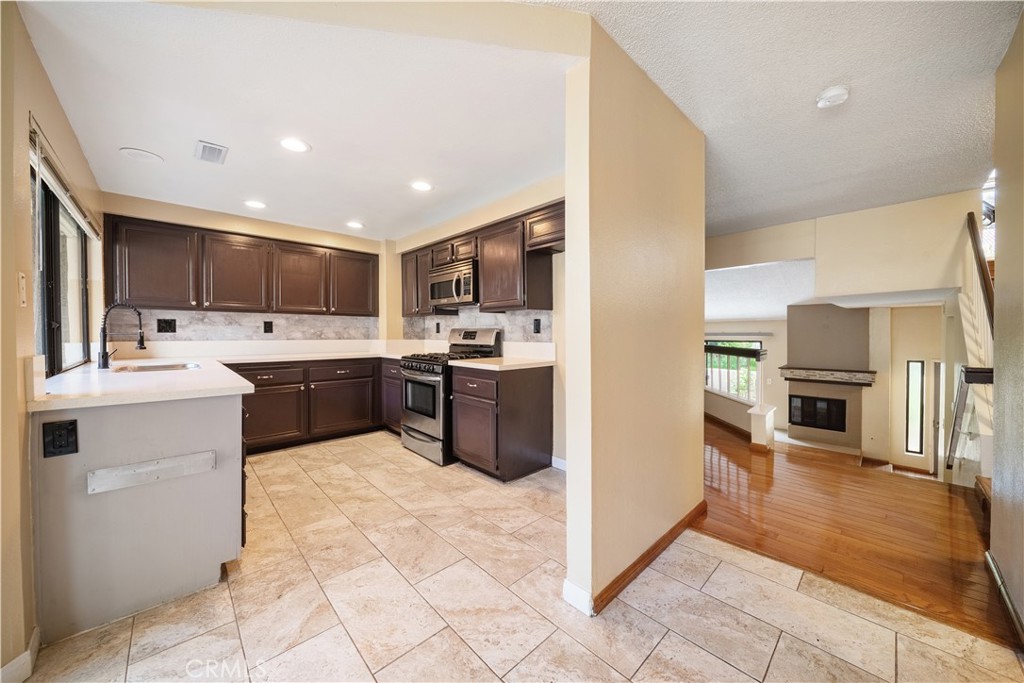 3 Saddlewood Lane Pomona, CA 91766 - Photo 10 of 40 a kitchen with kitchen island granite countertop a stove sink and cabinets