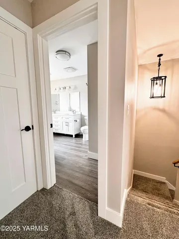 a view of a hallway with wooden floor and a living room