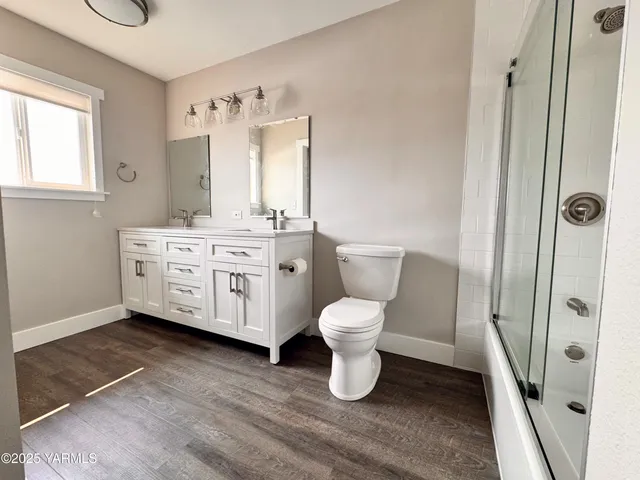 a spacious bathroom with a toilet sink and mirror