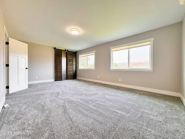 an empty room with windows and closet