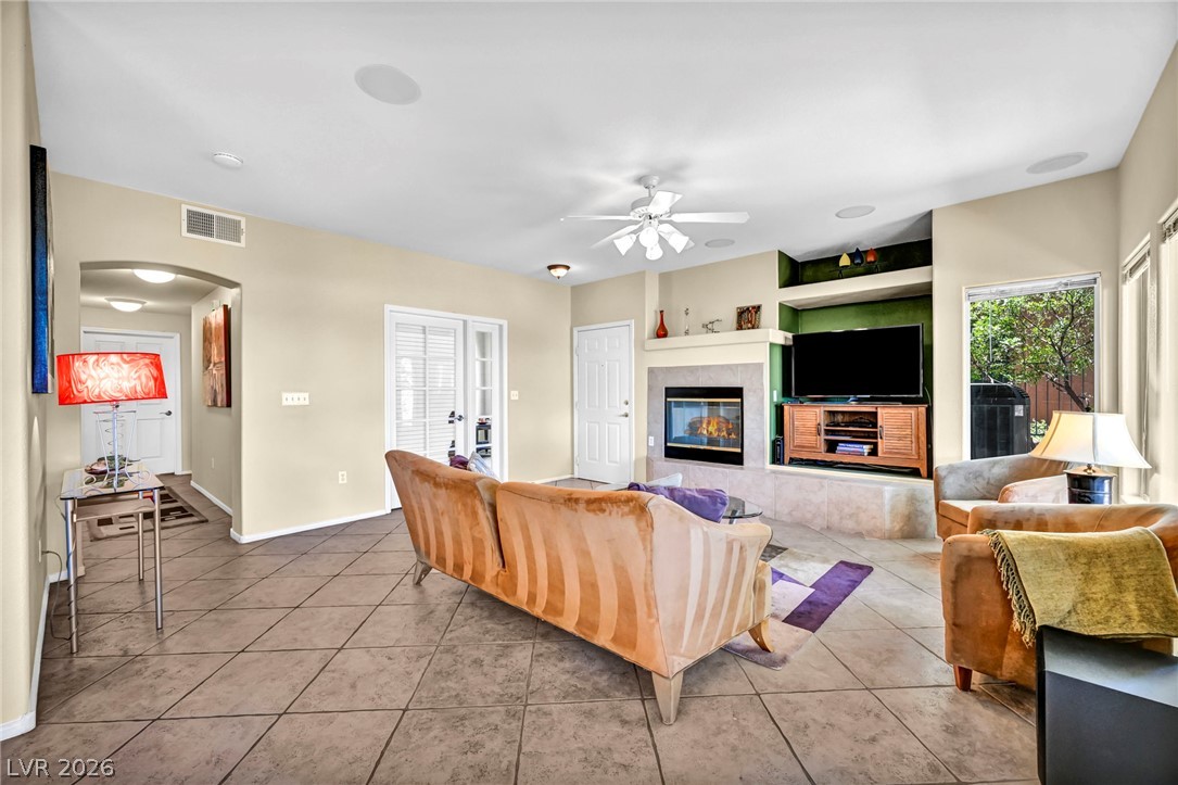10730 Amber Ridge Drive, Unit 101 Las Vegas, NV 89144 - Photo 9 of 32 A welcoming living area showcases a cozy fireplace and convenient sliding glass doors.