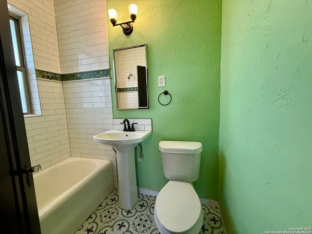 a bathroom with a sink a toilet a mirror and bathtub