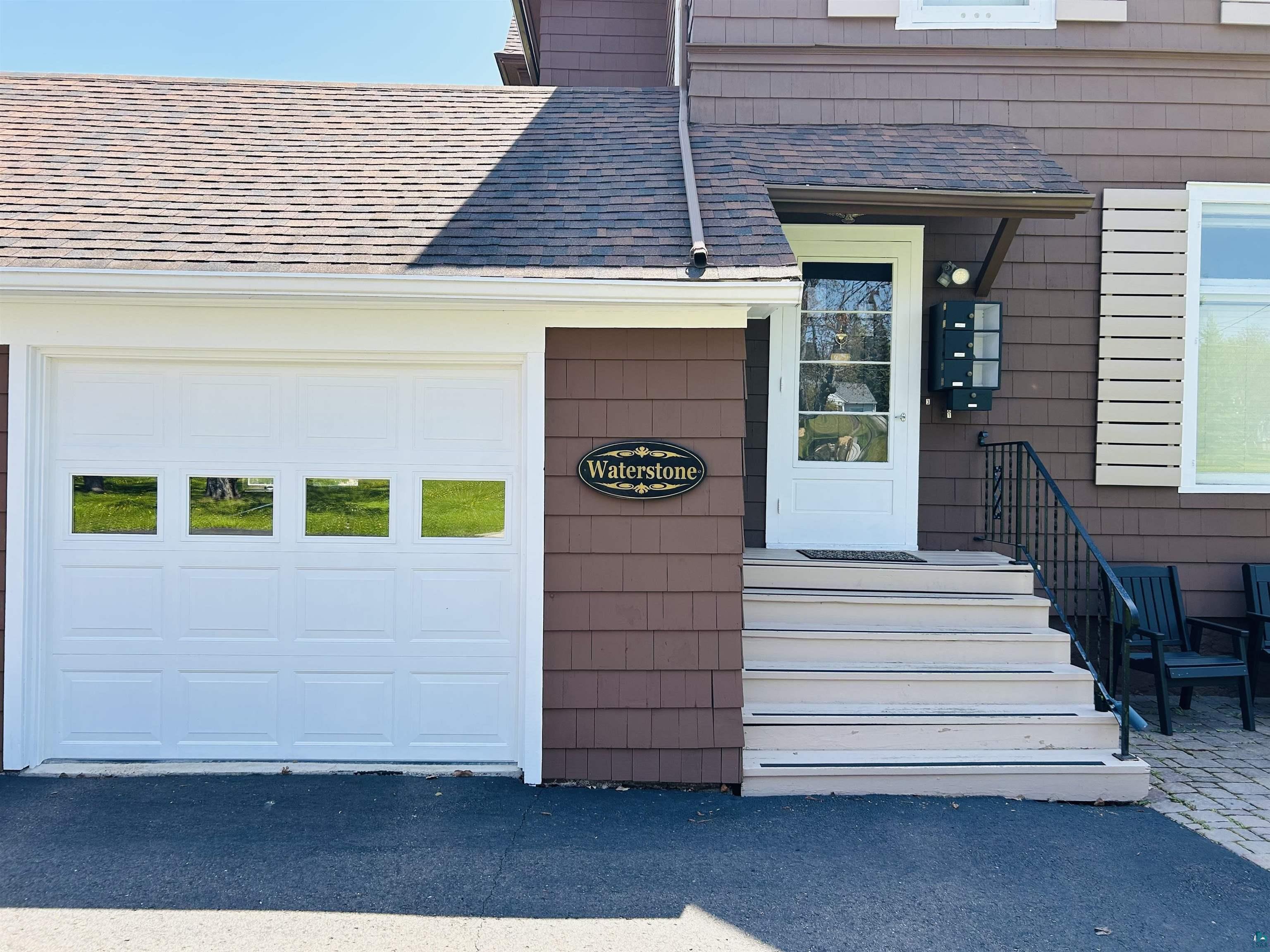 5090 London Road, Unit 1 Duluth, MN 55804 - Photo 4 of 54 Brown shingle siding exterior featuring a white garage door with window inserts