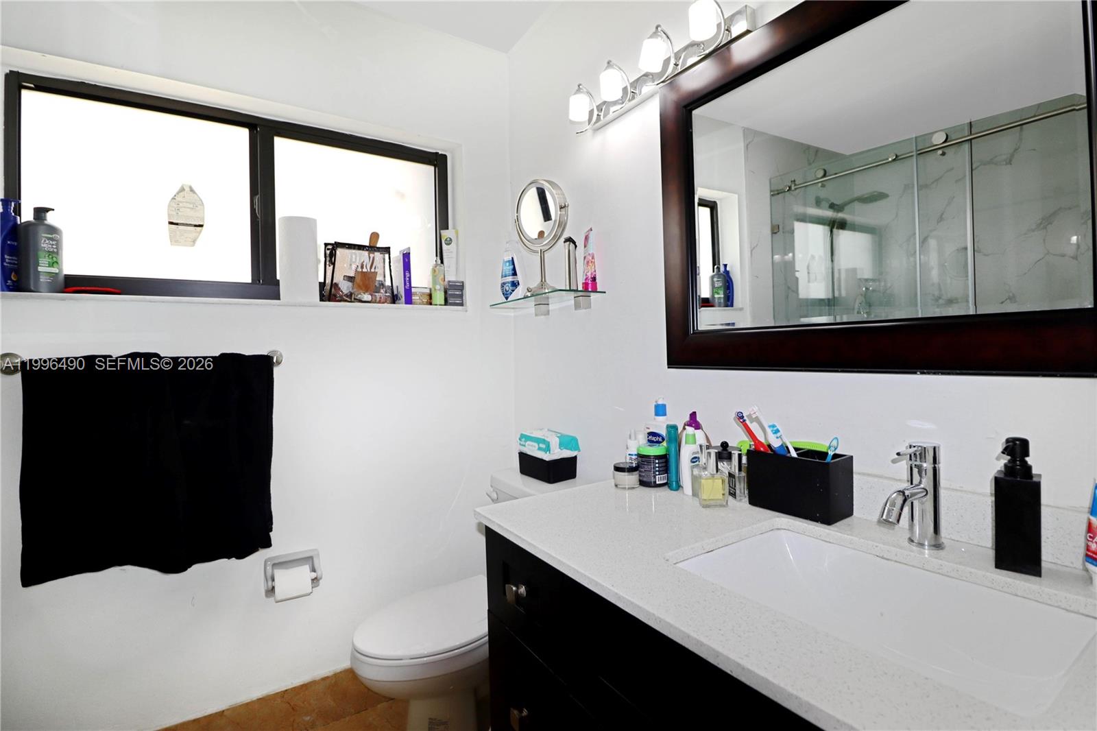 10940 Southwest 143rd Court Miami, FL 33186 - Photo 16 of 31 a bathroom with a sink vanity mirror and toilet