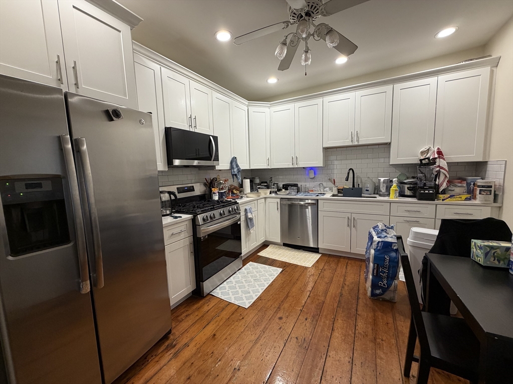 1675 Washington Street, Unit 3 Boston, MA 02118 - Photo 2 of 6 a kitchen with kitchen island granite countertop stainless steel appliances cabinets a sink and a counter top space