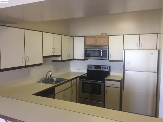 a kitchen with a sink stove and refrigerator