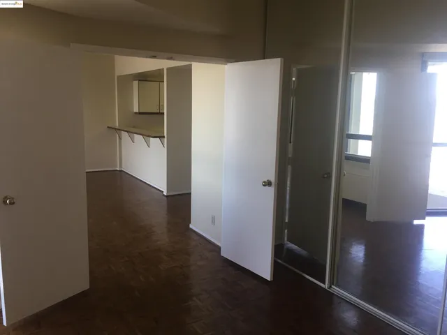 an empty room with wooden floor door and windows