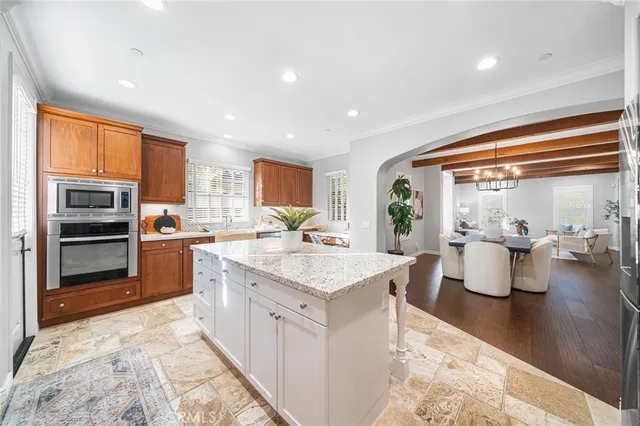 a large living room with stainless steel appliances kitchen island granite countertop furniture and a kitchen view