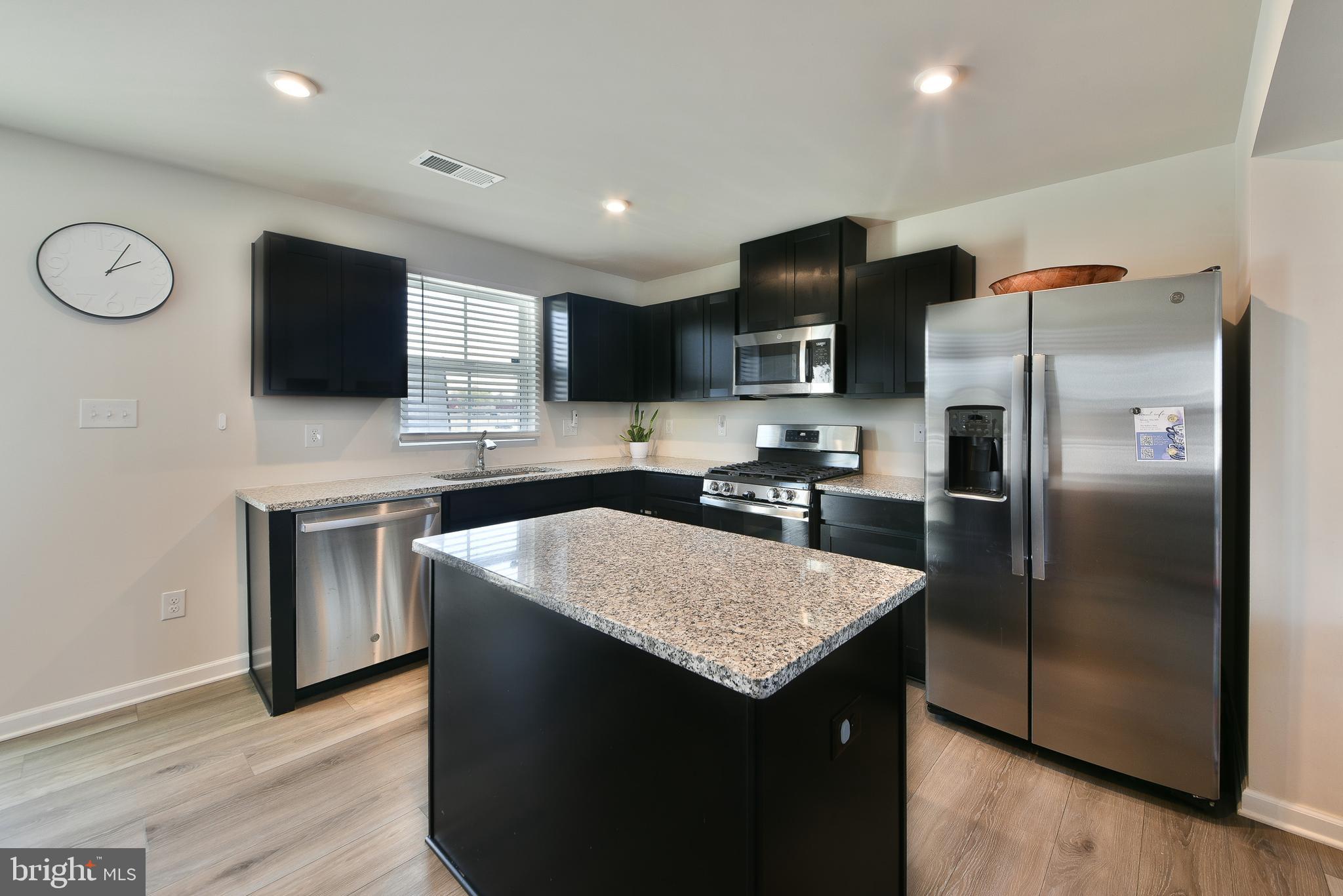 24 Wendowski Street Beverly, NJ 08010 - Photo 7 of 19 a kitchen with kitchen island granite countertop stainless steel appliances a sink stove refrigerator and cabinets