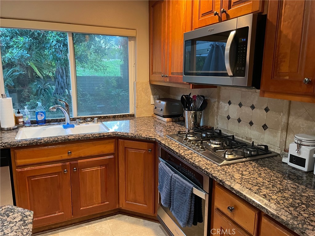 39 Bethany Drive Irvine, CA 92603 - Photo 18 of 37 a kitchen with granite countertop a stove sink and microwave