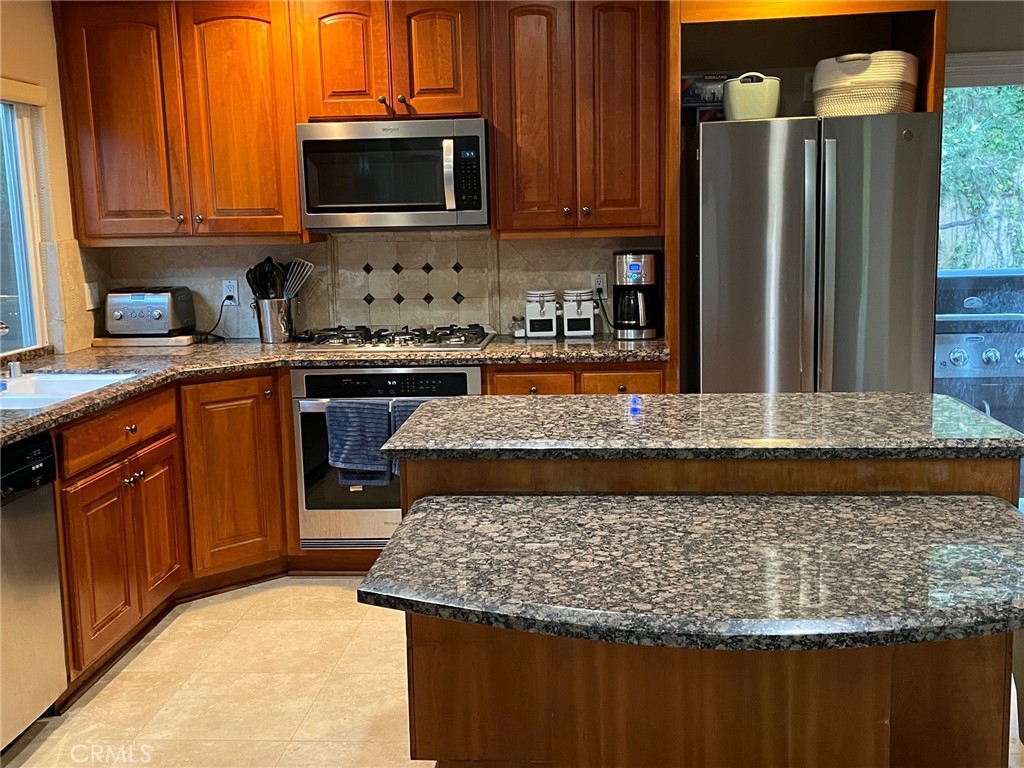 39 Bethany Drive Irvine, CA 92603 - Photo 19 of 37 a kitchen with wooden cabinets a stove top oven a sink and dishwasher