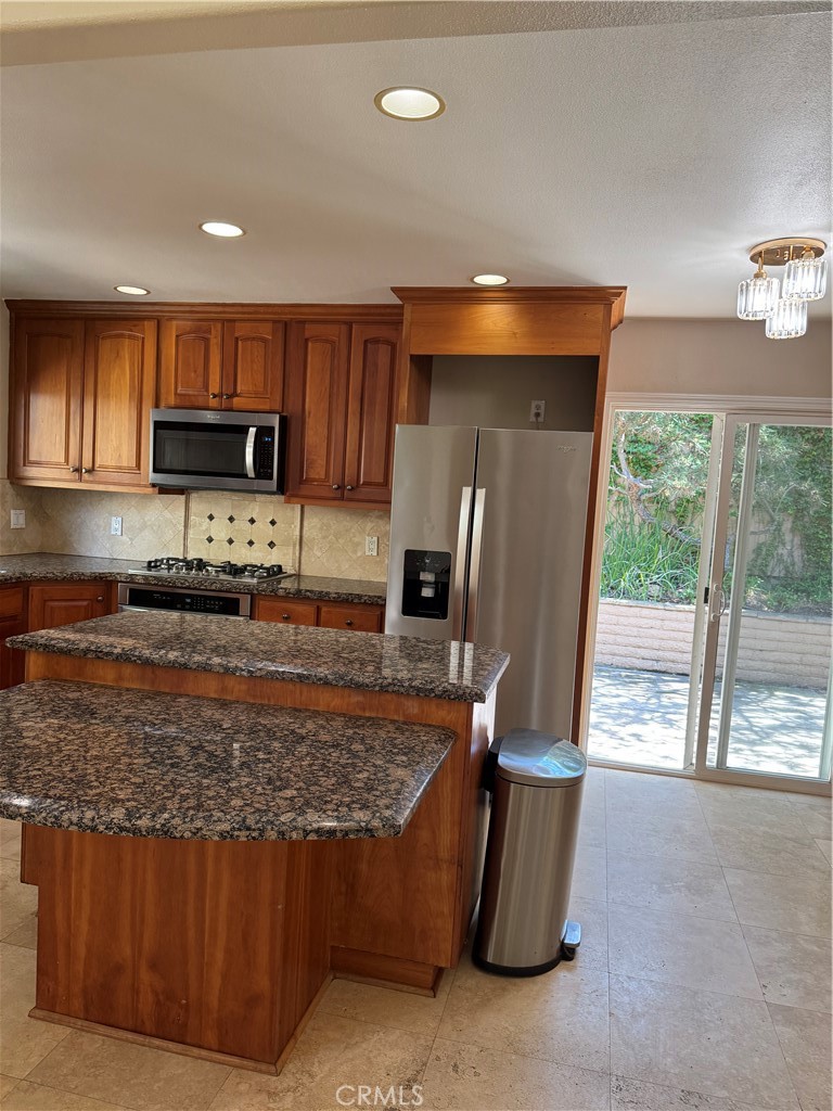 39 Bethany Drive Irvine, CA 92603 - Photo 20 of 37 a kitchen with stainless steel appliances granite countertop a stove top oven a sink and a refrigerator