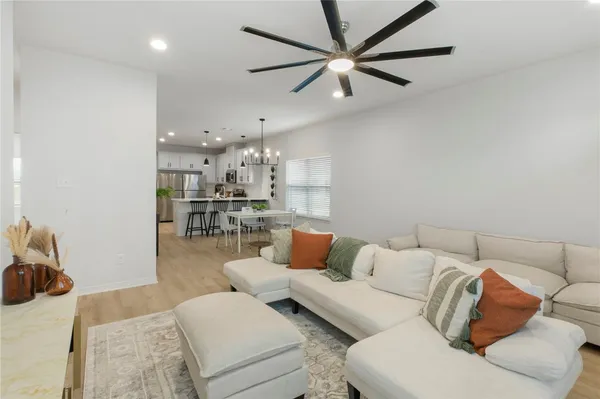 a living room with furniture and a view of kitchen