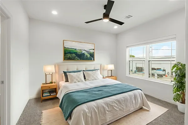 an empty room with windows and ceiling fan