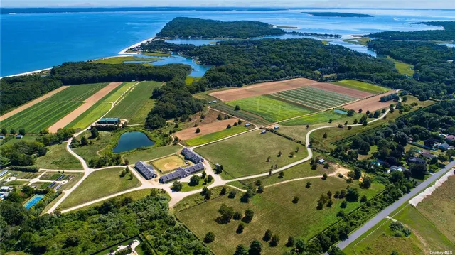 an aerial view of a tennis ground and a cars park side of a lake