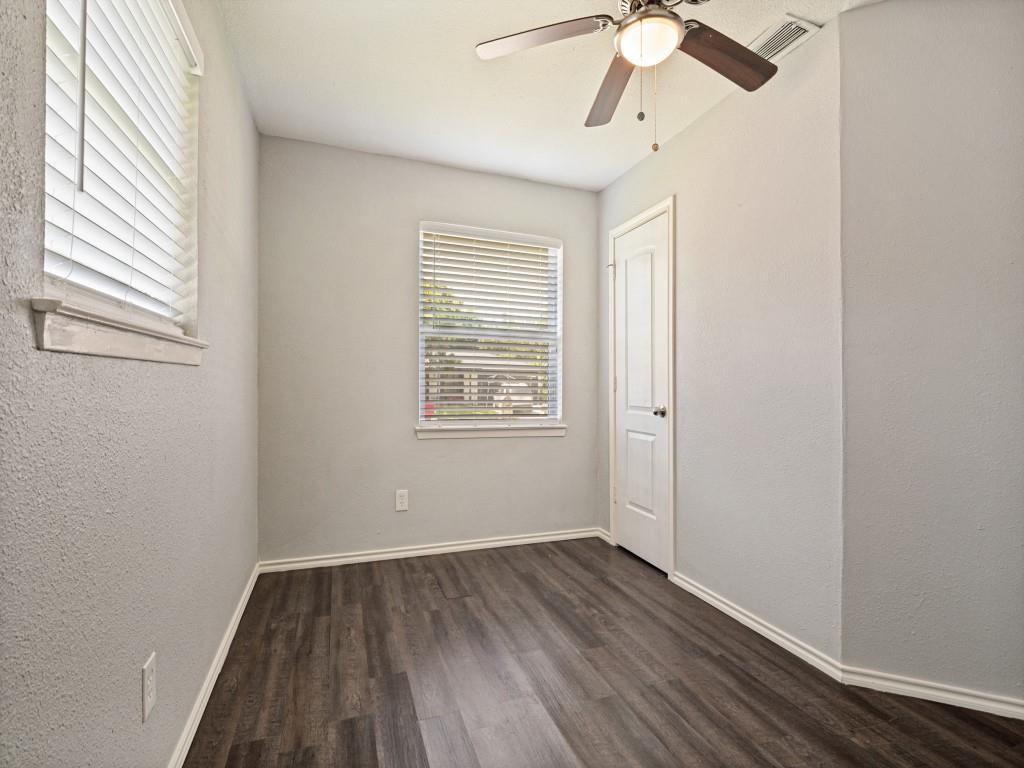 1405 Rambler Road Arlington, TX 76014 - Photo 15 of 26 Interior room featuring wood-finish flooring, two windows with blinds, light gray wall paint, and a ceiling fan with integrated lighting