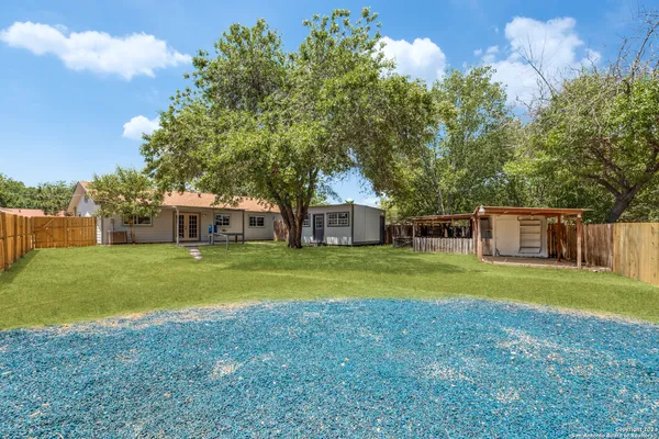 a front view of a house with a yard and trees