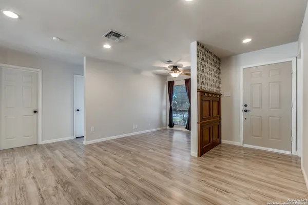 a view of empty room with wooden floor