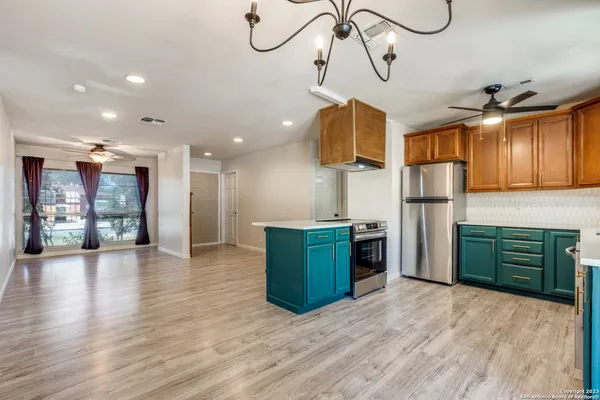a kitchen with stainless steel appliances granite countertop a refrigerator a sink dishwasher and a stove with wooden floor