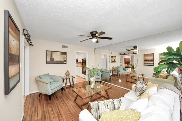 a living room with furniture and a wooden floor