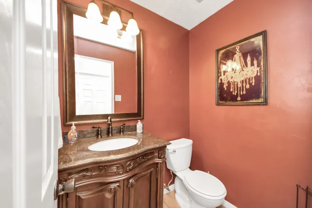 a bathroom with a toilet a sink and mirror
