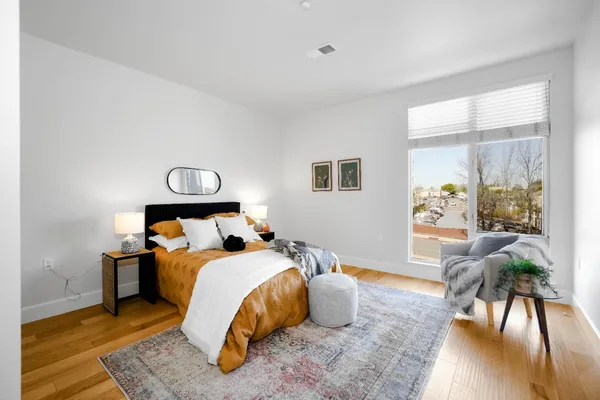 a bedroom with a bed and wooden floor