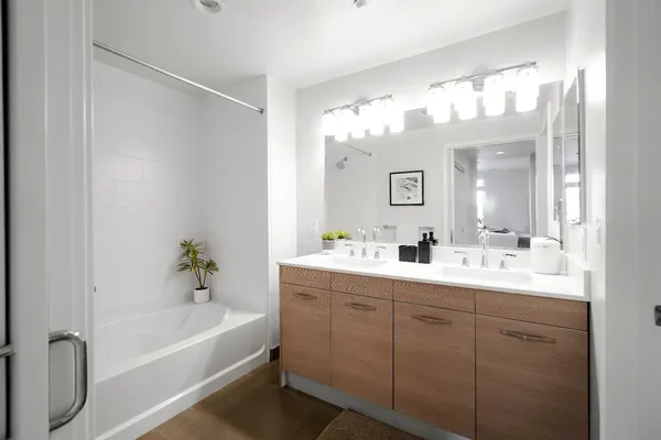 a bathroom with a tub a sink and mirror