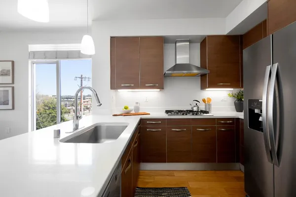 a kitchen with stainless steel appliances granite countertop a sink stove and refrigerator