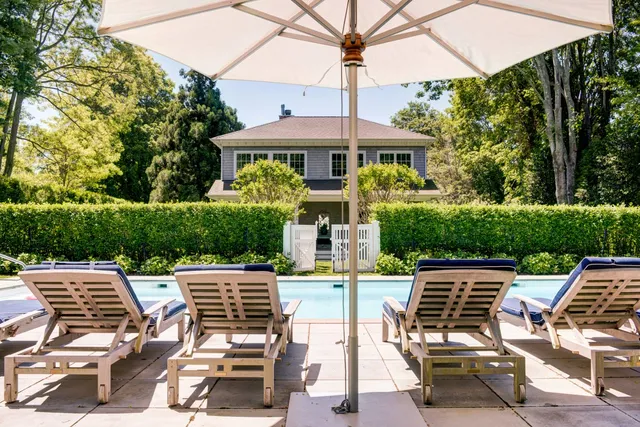 a view of a patio with a table and chairs under an umbrella
