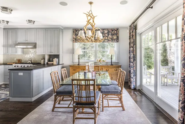 a dining room with wooden floor a chandelier a glass table and chairs