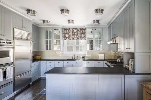 a kitchen with a sink a counter top space cabinets and stainless steel appliances