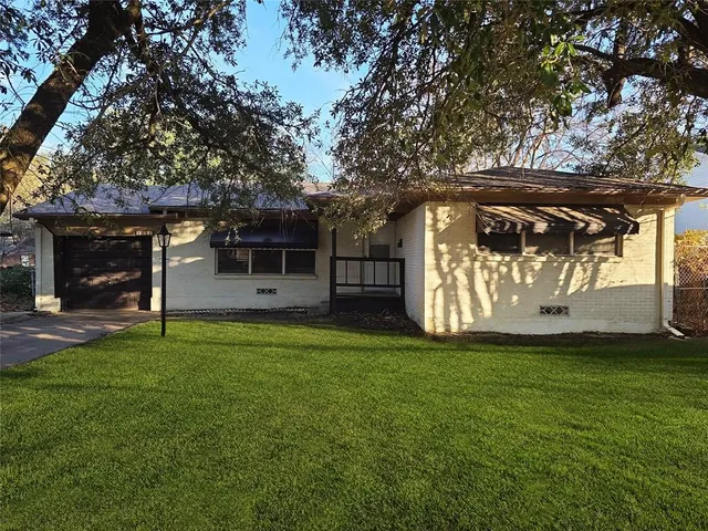 a view of a trees in front of a house with a large tree