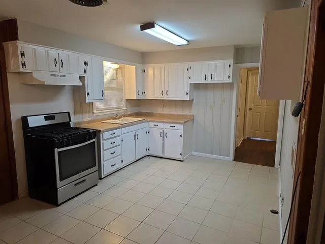 a kitchen with white cabinets and appliances