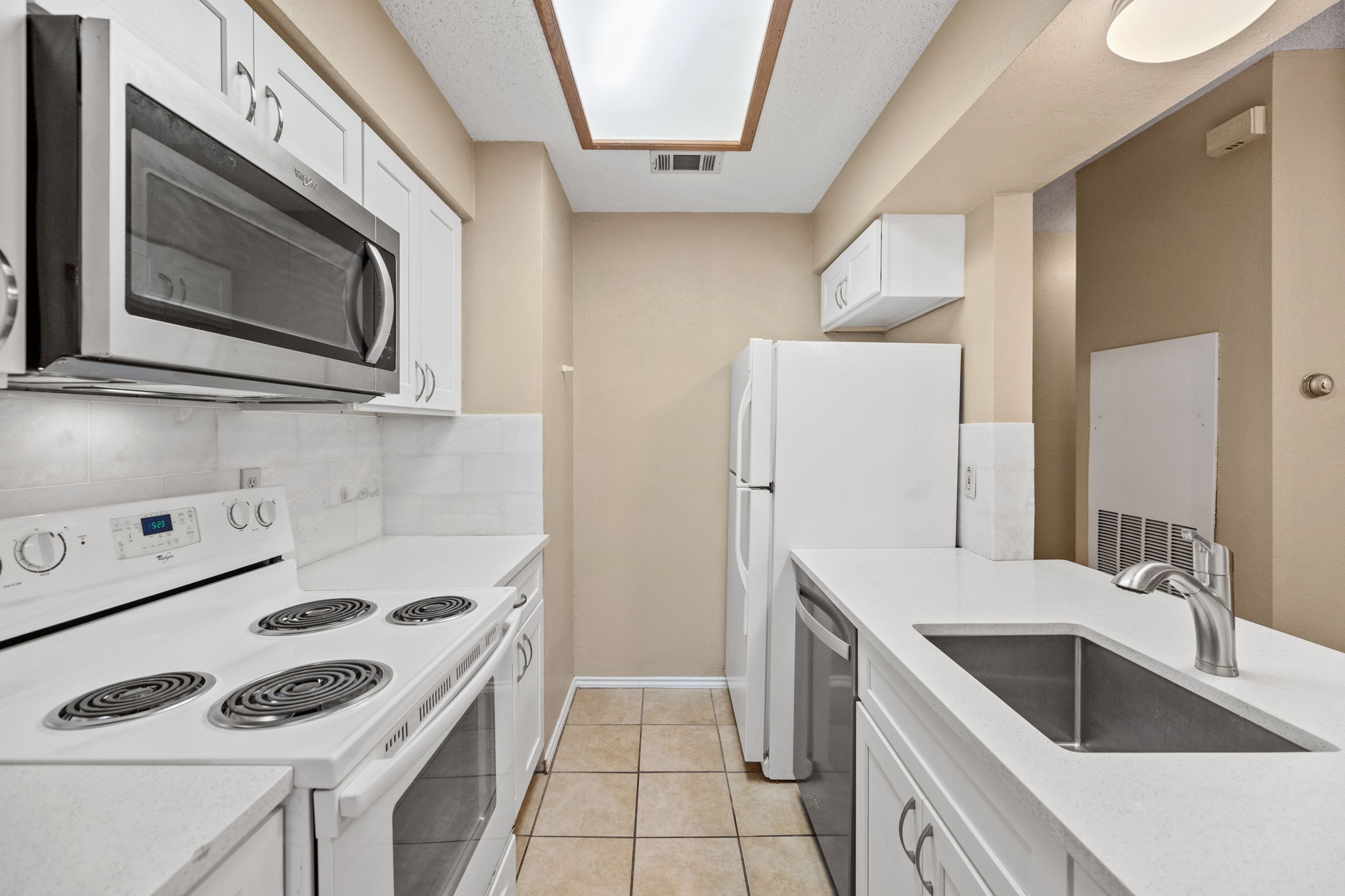2706 Salado Street, Unit 210 Austin, TX 78705 - Photo 12 of 32 a kitchen with granite countertop a sink a stove and refrigerator
