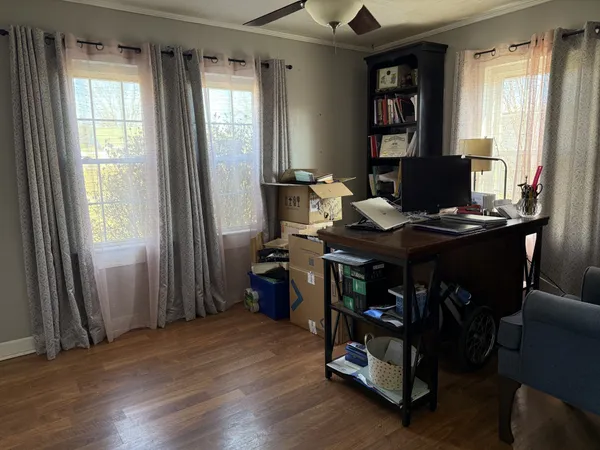 a view of a workspace with furniture and a window