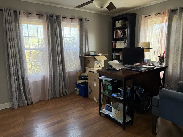 a view of a workspace with furniture and a window