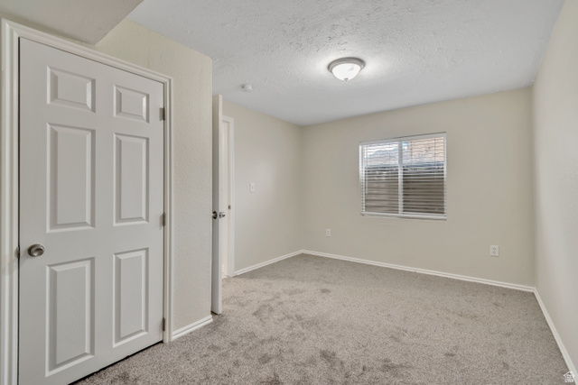 1118 North Ridge Court Spanish Fork, UT 84660 - Photo 30 of 32 Empty room with a textured ceiling and light carpet