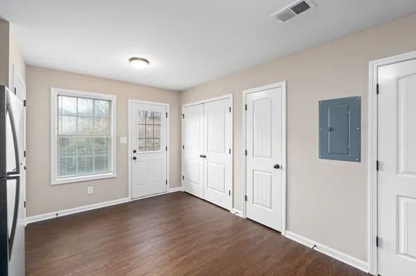 an empty room with wooden floor and windows