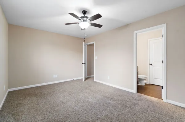 an empty room with closet and a chandelier fan